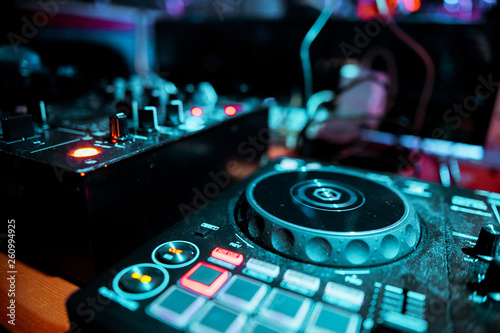 Night club, nightlife concept. DJ hands hold microphone and mixing DJ remote. Neon light