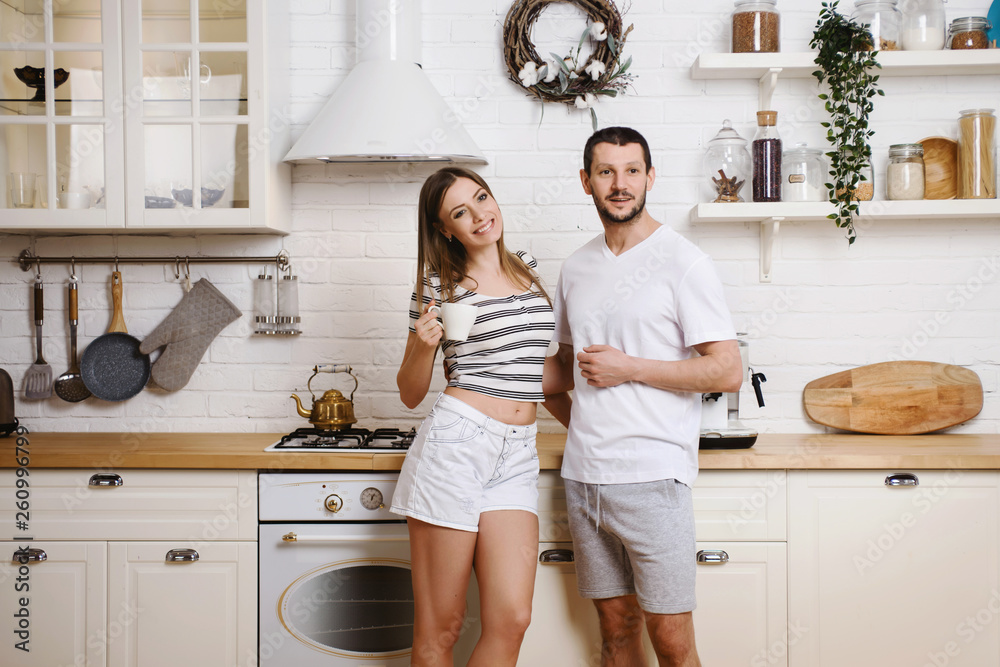 Happy couple woman and man making coffee with machine at their kitchen in new home. Having fun together and cooking breakfast. Happy young family concept Happy couple woman and man making coffee with machine at their kitchen in new home. Having fun together and cooking breakfast. Happy young family concept