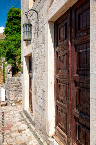 Ancient brick building in the fortress old bar, Montenegro. Antique wooden door and old lantern. Summer.
