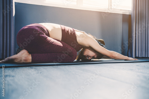young woman practicing yoga in class; Beautiful girl feeling Calmness and relax in yoga class