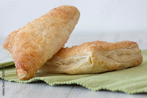 Apple turnover on a green tea towel with a grey wood background