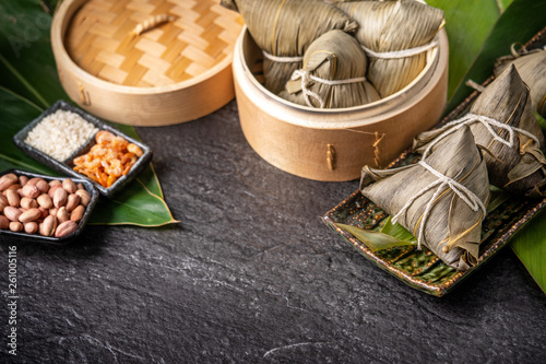 Close up, copy space, top view, famous asian chinese tasty handmade food in dragon boat(duan wu) festival, steamed rice dumplings shaped pyramidal by leaves ingredients photo