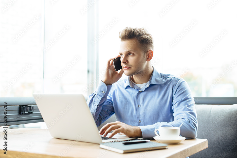 Stylish young man calling by the phone to solve business problems. Online consultation by phone. Freelancer discussing the development and planning of his online project. Outsourcing. Mobile services. Stylish young man calling by the phone to solve business problems. Online consultation by phone. Freelancer discussing the development and planning of his online project. Outsourcing. Mobile services.