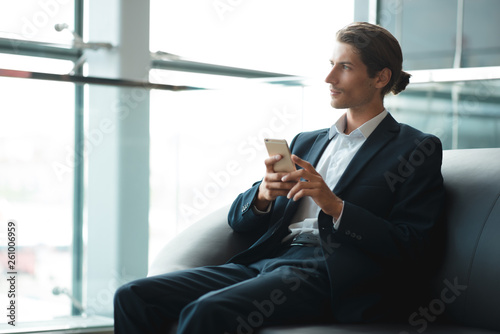 Adult serious man has business conversations using on-line mobile application. Developer innovational business web applications in the internet. Stylish guy. Business portrait. Cloud technologies.