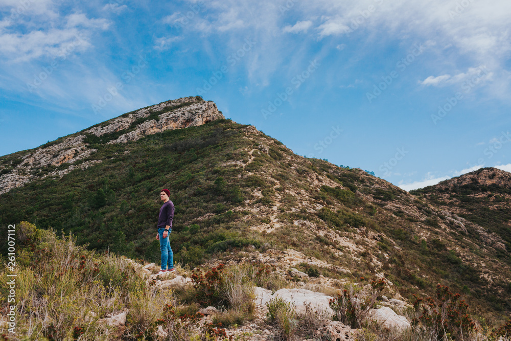 Young male hikes in mountains. Landscape scenery of spanish nature.