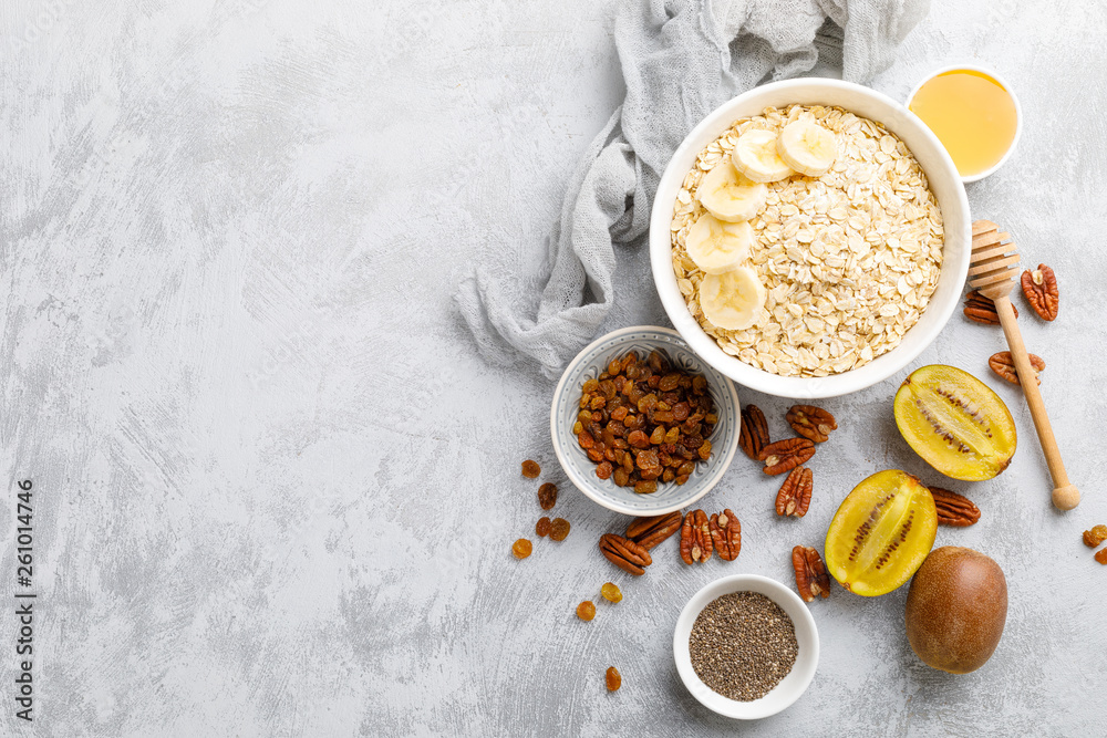 Oat flakes with fruits, nuts and honey in bowl Oat flakes with fruits, nuts and honey in bowl
