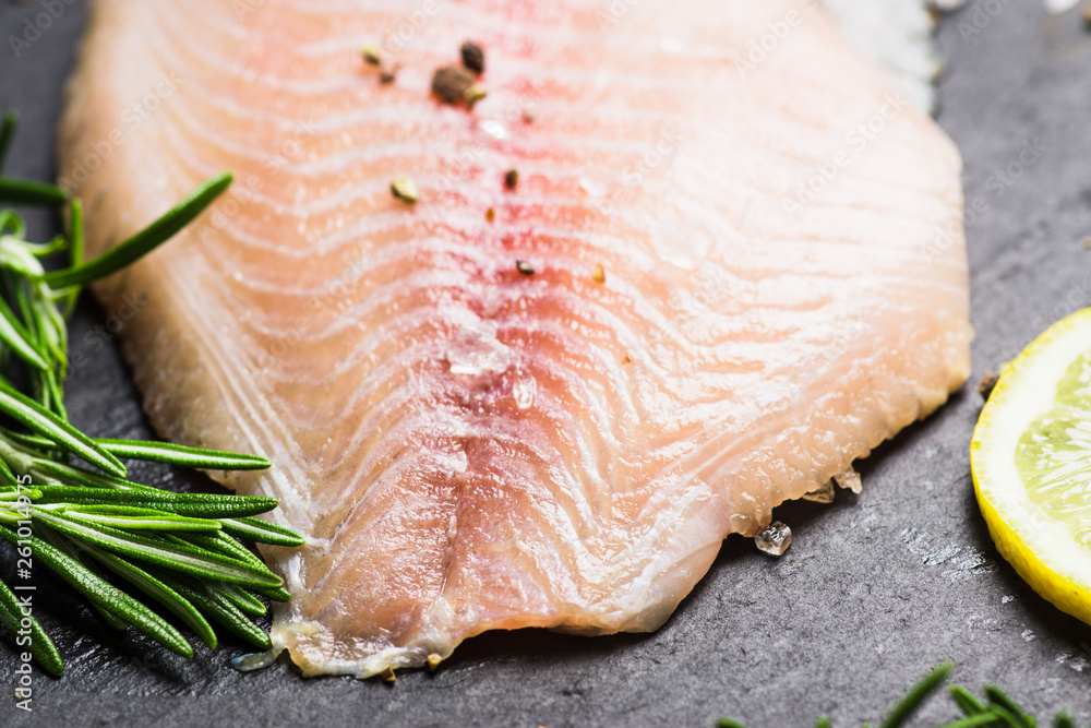 Raw tilapia fish fillet on the cutting board. Selective focus. Shallow depth of field. Raw tilapia fish fillet on the cutting board. Selective focus. Shallow depth of field.