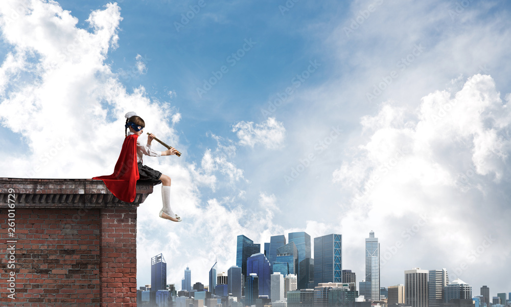 Girl power concept with cute kid guardian against cityscape background. Mixed media Girl power concept with cute kid guardian against cityscape background. Mixed media