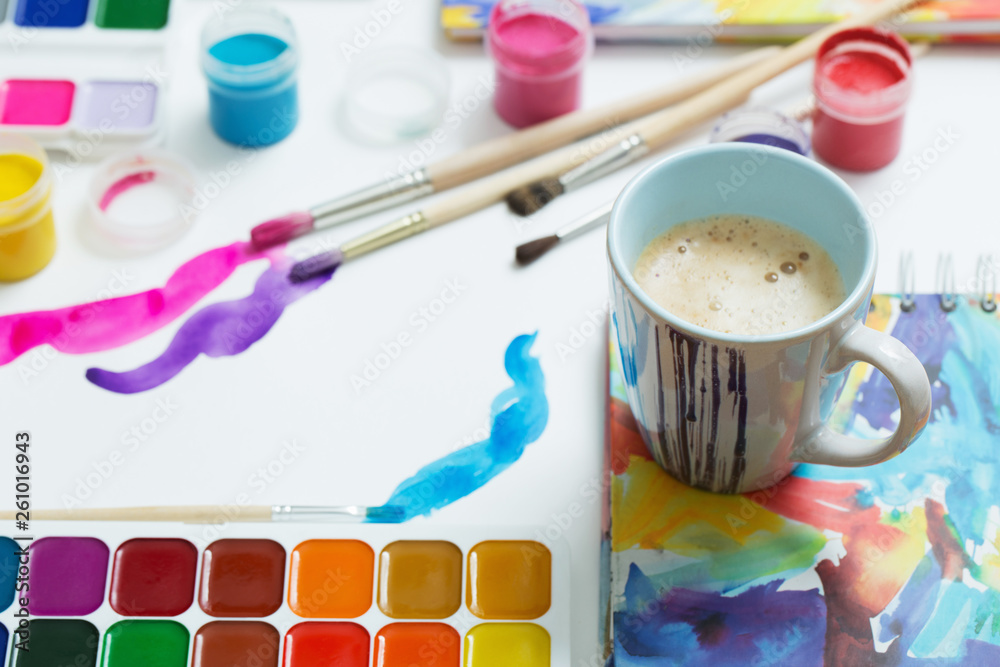paints, brushes and cup of coffee on paper paints, brushes and cup of coffee on paper