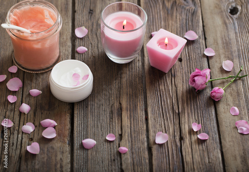 cosmetic mask and burning candle on old wooden background photo