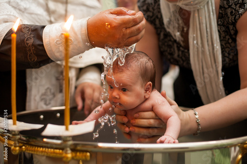 Canvas Print Newborn baby baptism in Holy water
