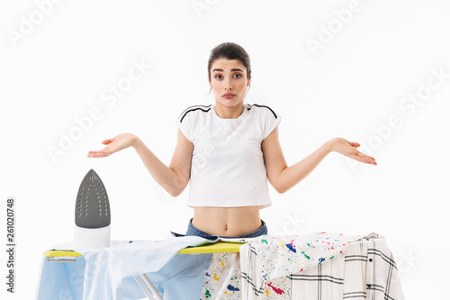 Photo of brunette woman housewife 20s dressed in casual wear ironing clean clothes on board