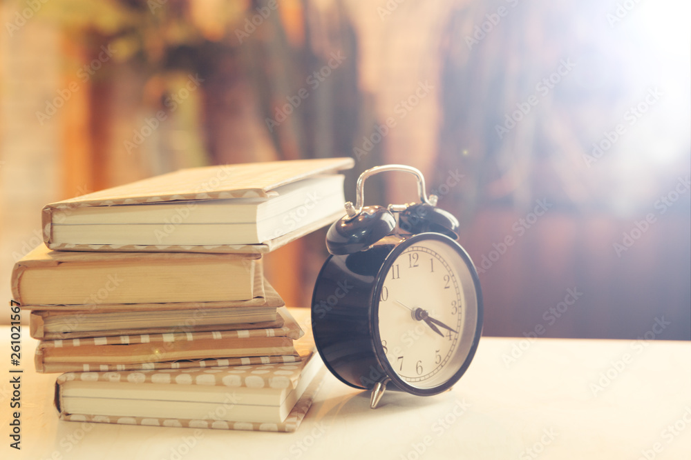 alarm clock near books on the table alarm clock near books on the table