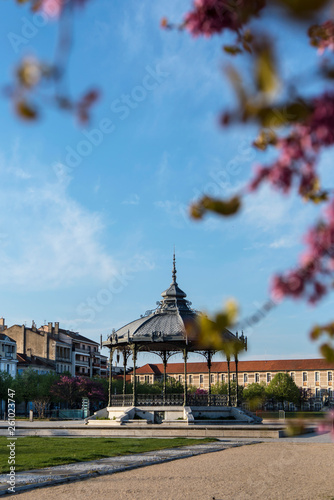 Famous bandstand kiosk Peynet surrounded by pink flowers on the Champs de Mars in Valence city. France 2019.