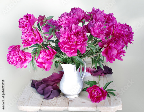 Bouquet of pink peonies in a basket.Still life with pink peonies on white.