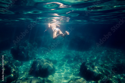 underwater view of a woman swimming relaxed at sea © Raul Mellado