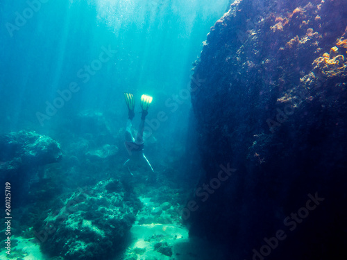 Man dives to the bottom of sea near the coast
