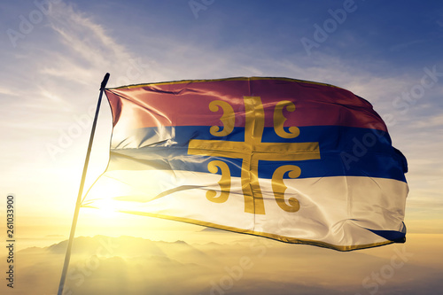 Serbian Orthodox Church flag waving on the top sunrise mist fog