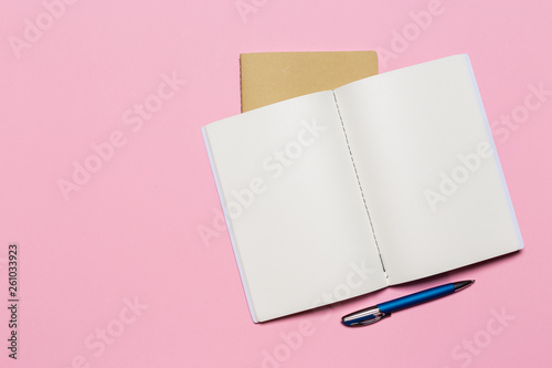 school notebook on a pink background, notepad on a table