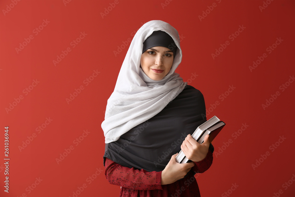 Muslim woman with books on color background Muslim woman with books on color background