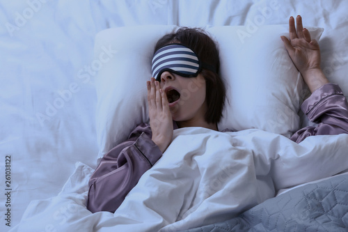 Tired woman with sleep mask...