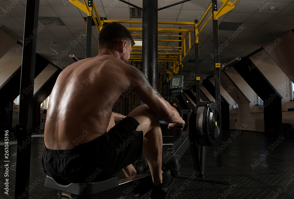 Muscular man using rowing machine Muscular man using rowing machine