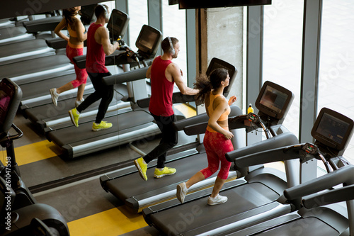 Couple run on treadmills in...