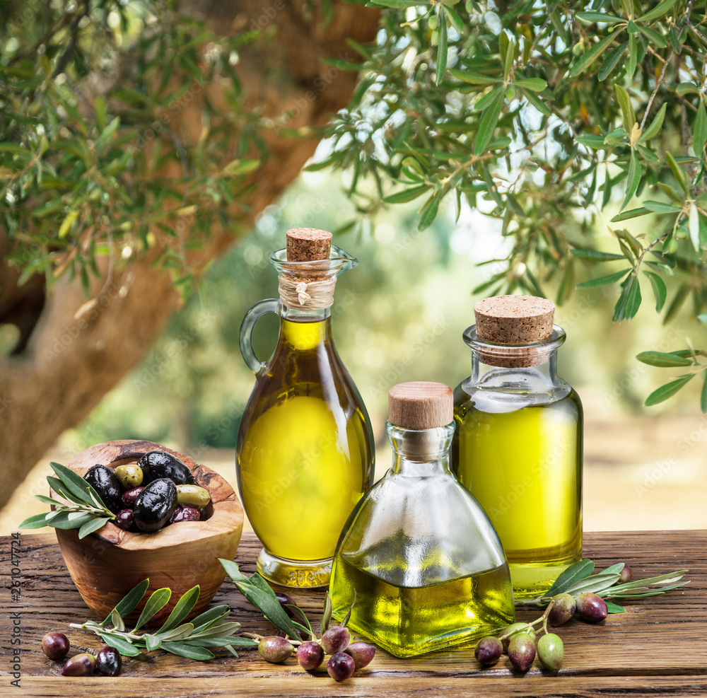 Olive oil and berries are on the wooden table under the olive tree  Fotótapéta, Fali tapéta, Tapéta az Europosters.hu-n,