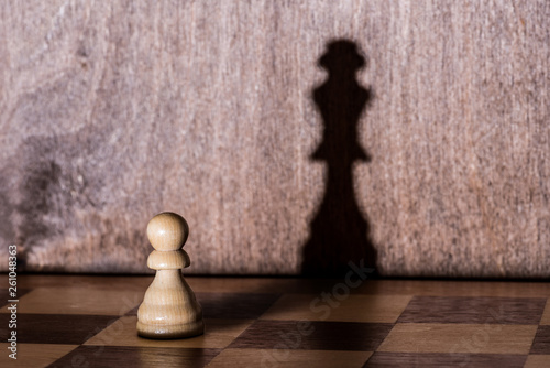 Chess pawn with queen shadow on chess-board Fototapet
