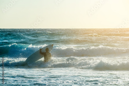 Fotografie Young man, beginner Surfer learns to surf on a sea foam on the Crete island, bea