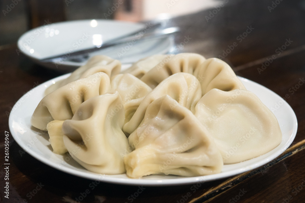 Asian cuisine. National Georgian food khinkali with Satsebeli sauce in a white plate. Tbilisi, Georgia