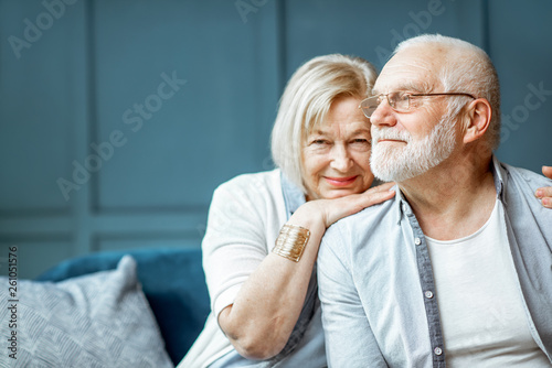 Obraz na płótnie Portrait of a beautiful senior couple embracing each other, sitting on the couch at home w salonie