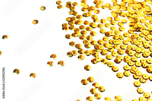 gold sequins scattered on white background