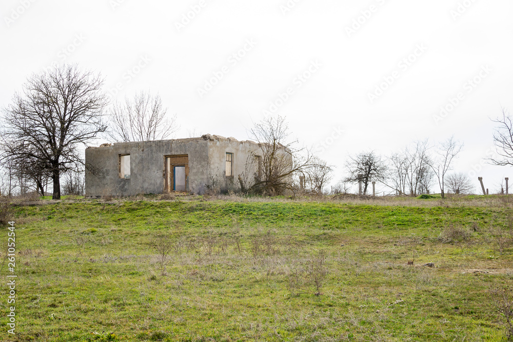 The ruins of an old earthen house without a roof. Holes in the wall at the site of windows and doors. The ruins of an old earthen house without a roof. Holes in the wall at the site of windows and doors.