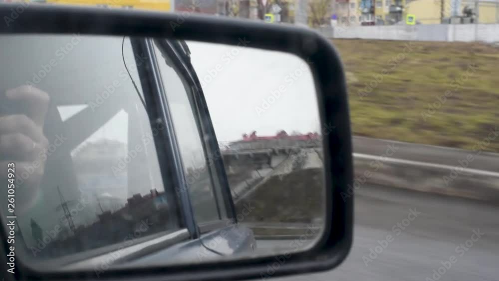 Right dirty car rear view mirror, mirror view View through the dirty mirror of a retro car, a house road and a car driving behind with the dipped headlights on. svetofory and road signs Right dirty car rear view mirror, mirror view View through the dirty mirror of a retro car, a house road and a car driving behind with the dipped headlights on. svetofory and road signs