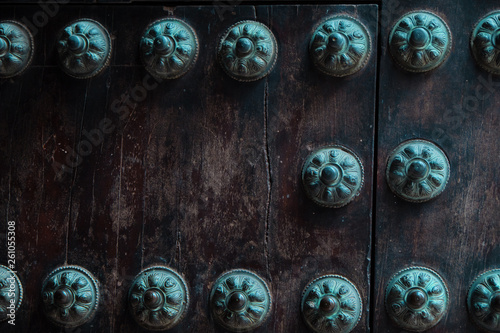 Close-up of old studded door detail with multiple decorative studs.
