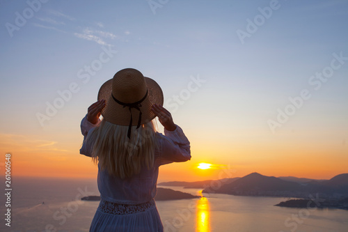 The girl looks at the sunset on the seashore
