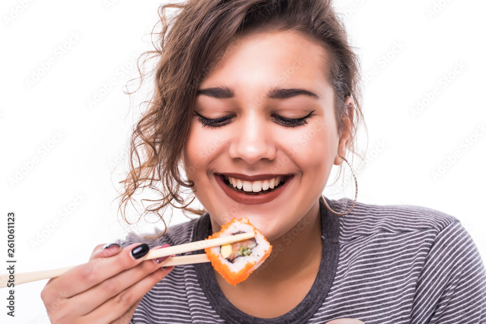 Beautiful young woman holding sushi with a chopsticks, isolated on white background Beautiful young woman holding sushi with a chopsticks, isolated on white background