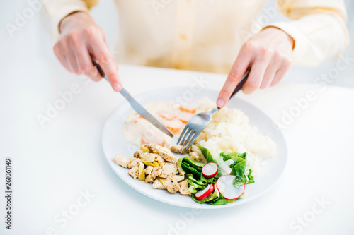 Close up food hands and dish on table woman eating rice meat salad sauce having lunch