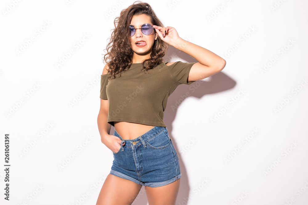 Fashionable funky woman in summer clothes with sunglasses posing playfully isolated on white background. Fashionable funky woman in summer clothes with sunglasses posing playfully isolated on white background.