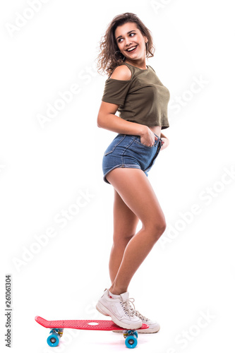 Full length portrait of a happy excited woman riding a skateboard isolated over white background