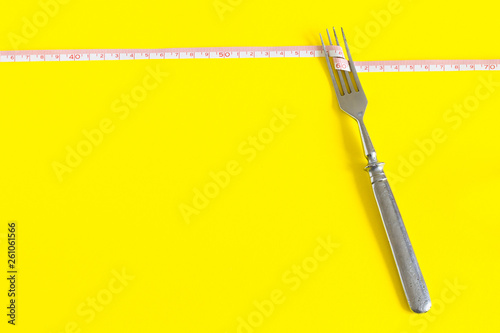 Diet concept. Fork on a white plate with centimeter. Time to lose weight , eating control or time to diet concept.