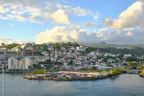 Scenic view of little town Fort-de-France with cloudy blue sky - capital of small island Martinique in the Caribbean sea. Beautiful summer look of town on green tropical island photo