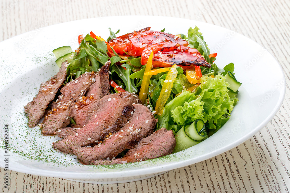 Salad with roast beef and sun-dried tomatoes on white background