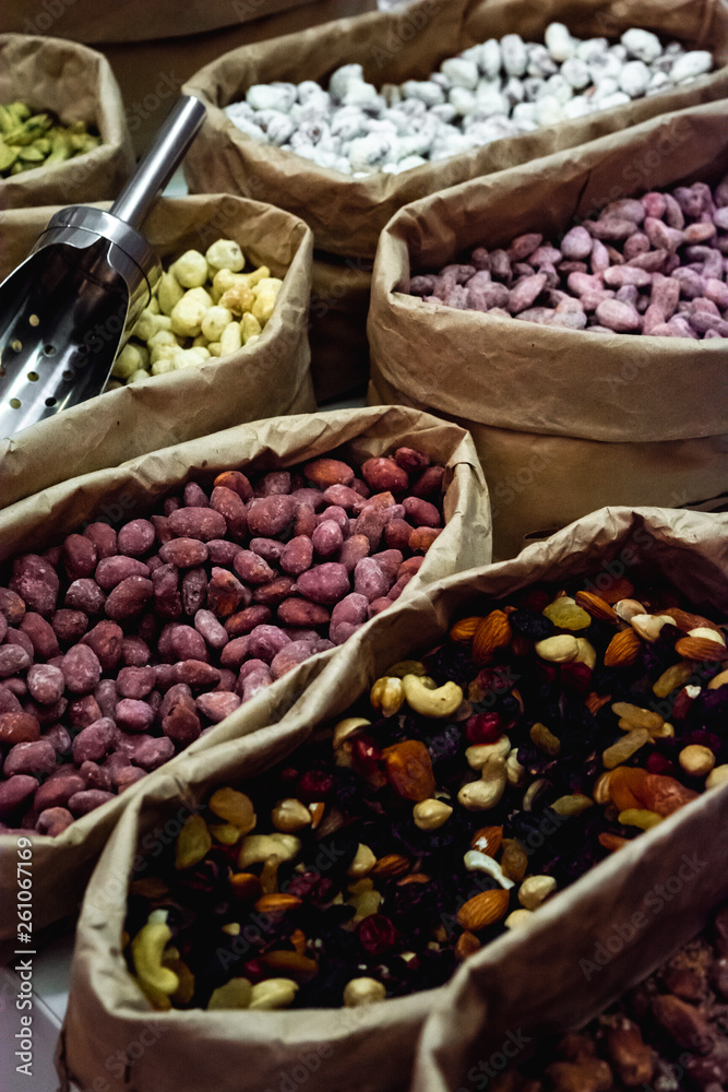 Raw nuts in paper bags at a market place. Peanuts, cashews and almonds. Raw nuts in paper bags at a market place. Peanuts, cashews and almonds.