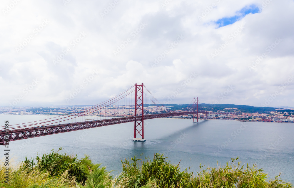 Ponte 25 de Abril Bridge in Lisbon, Portugal. Connects the cities of Lisbon and Almada crossing the Tagus River. View from Almada with Lisbon across