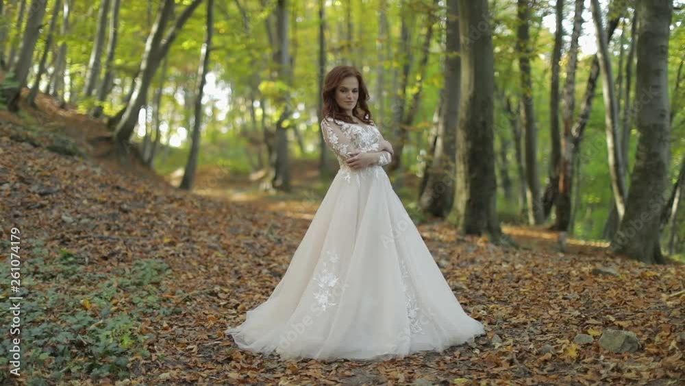 Bride in wedding dress stay in the forest park. Happy. Woman in love Bride in wedding dress stay in the forest park. Happy. Woman in love
