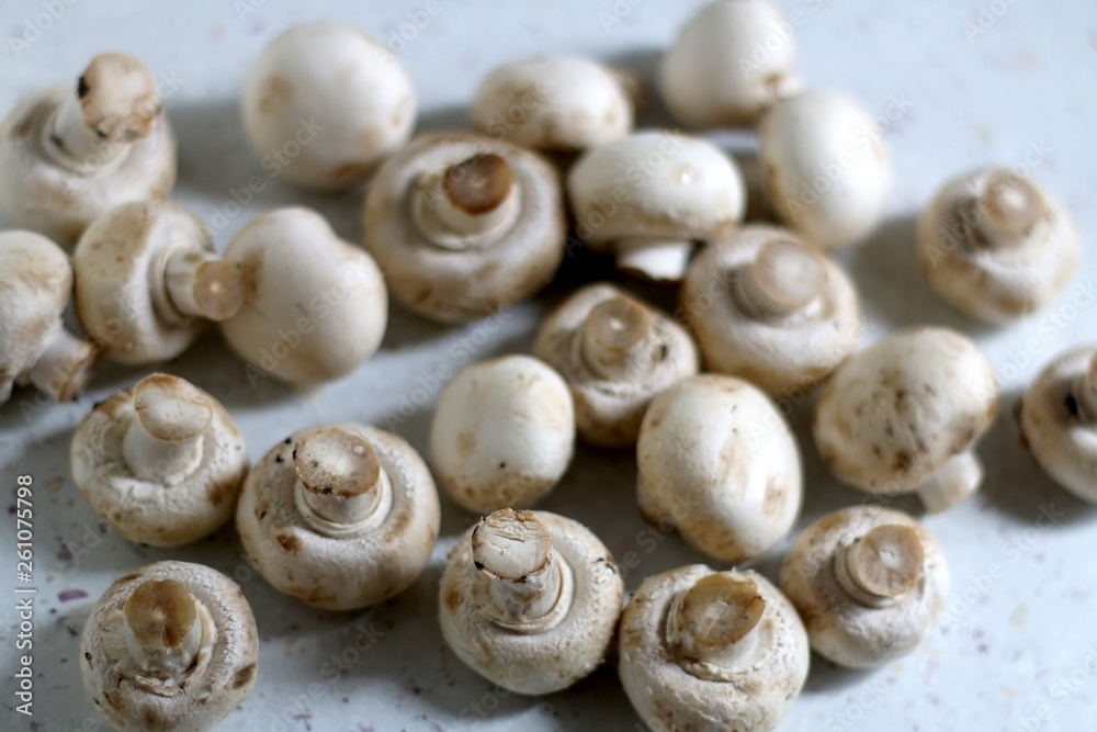 Champignon mushrooms on marble background. Top view, selective focus.