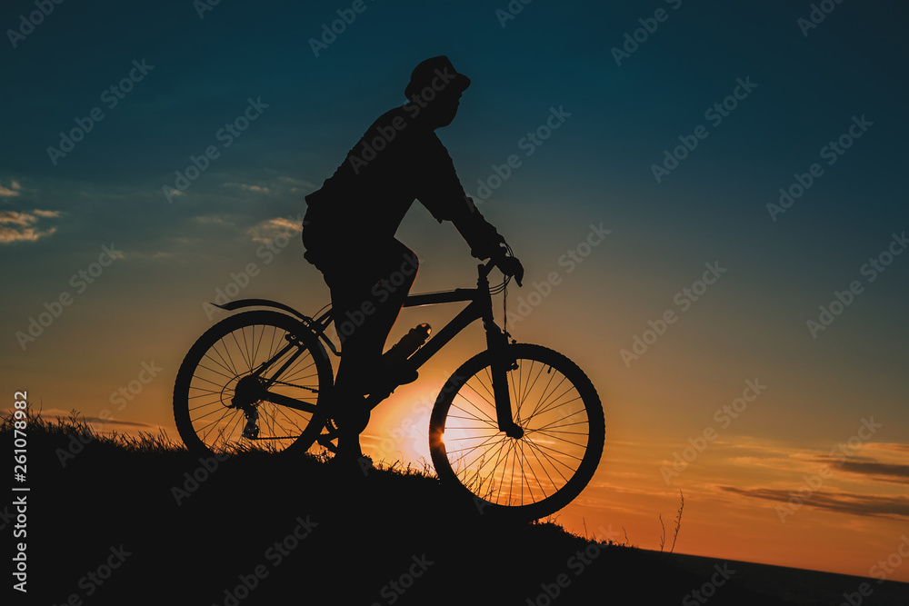 Silhouette of a male mountainbiker at sunset in the mountains