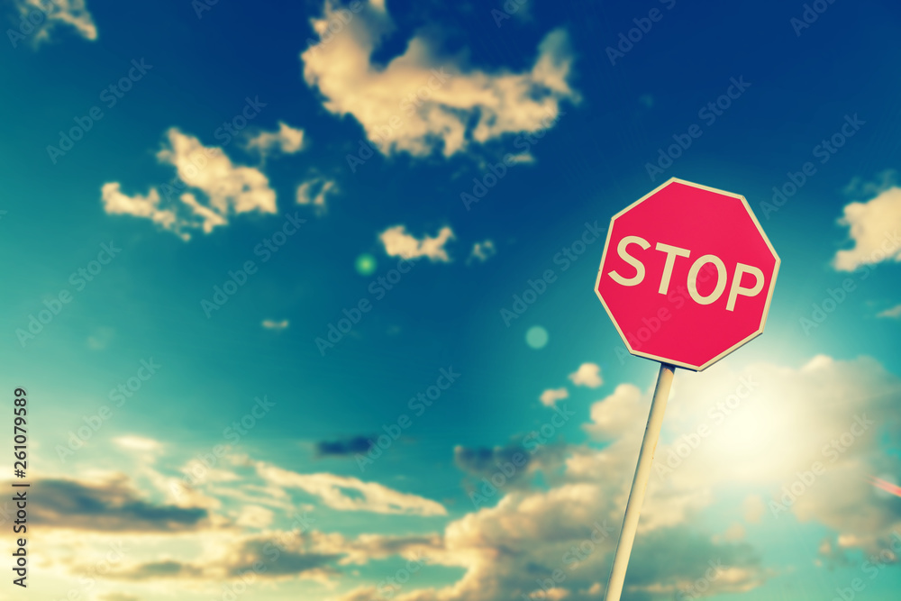 Red road stop sign on a blue sky background - obrazy, fototapety, plakaty 